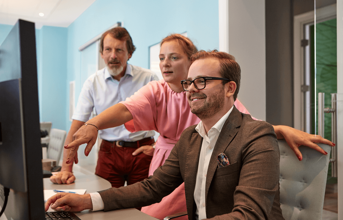 Picture of 3 colleagues looking at a computer screen